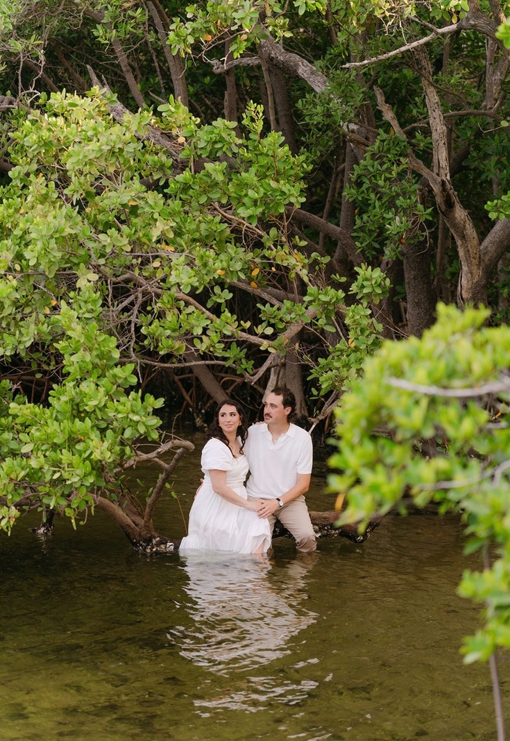 Claudia and Marcus seated together in a quiet mangrove cove.