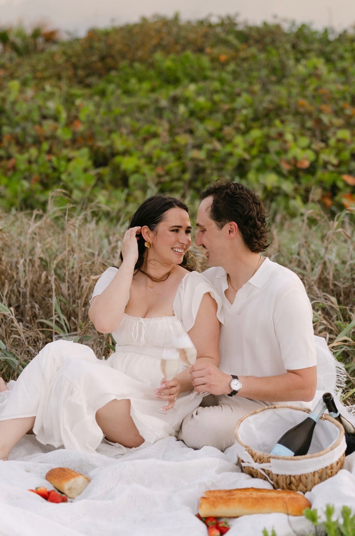 Claudia and Marcus smiling at each other during their picnic.