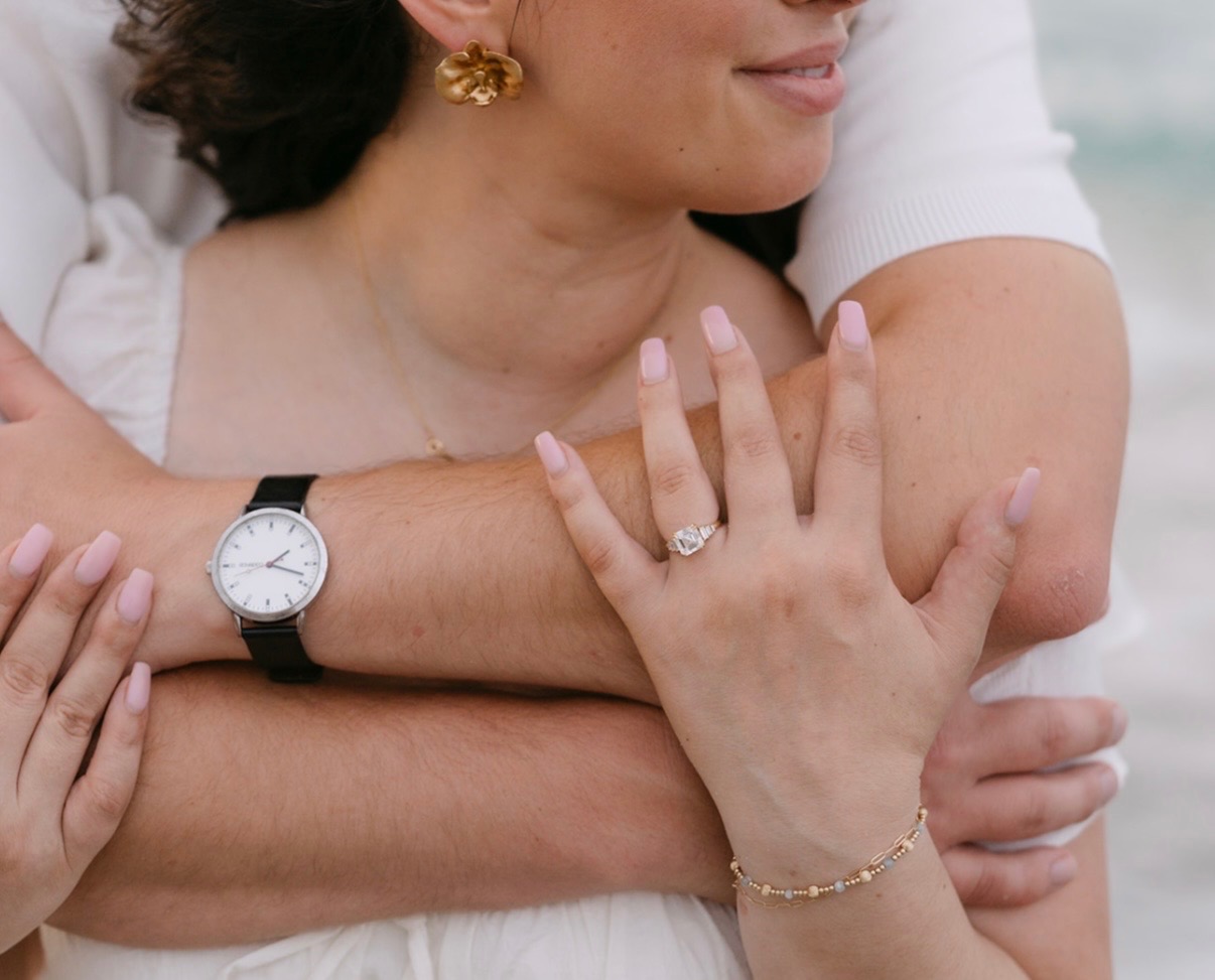 Close-up of Claudia's engagement ring and Marcus's watch.