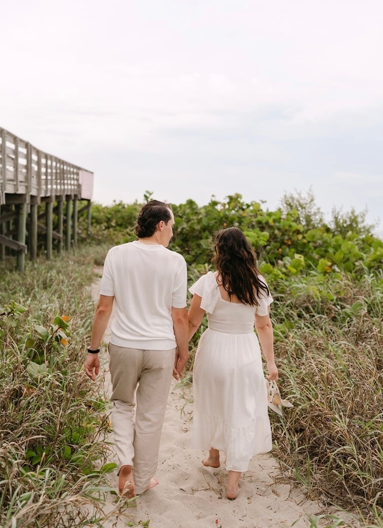 Claudia and Marcus walking toward the beach hand in hand.