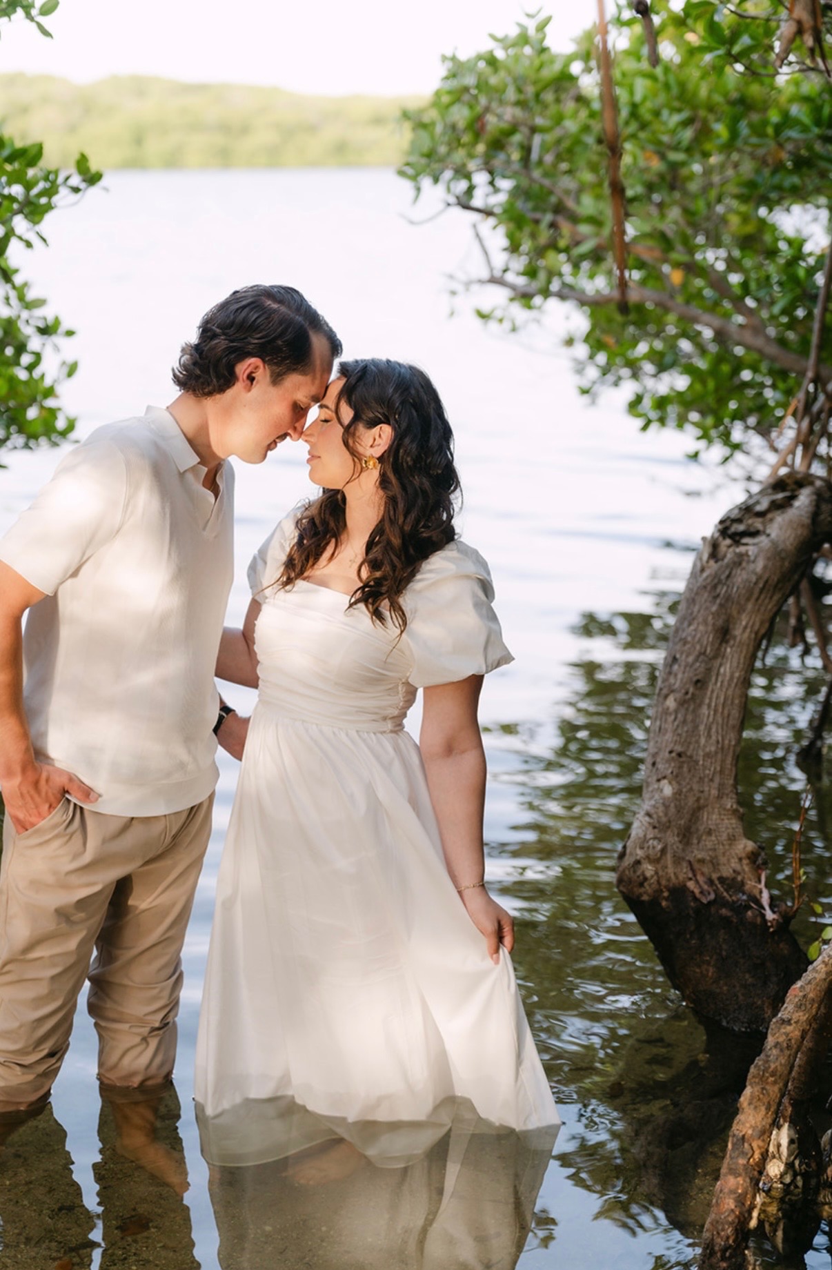 Claudia and Marcus touching foreheads in bright water.