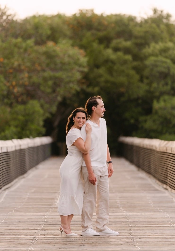 Claudia and Marcus standing together on a wooden beach boardwalk.